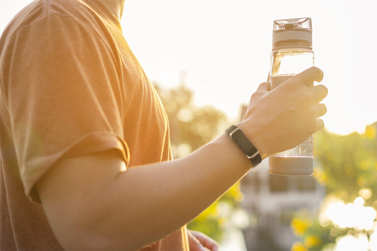Mann hält Wasserflasche in der Hand und trägt Hilo Band